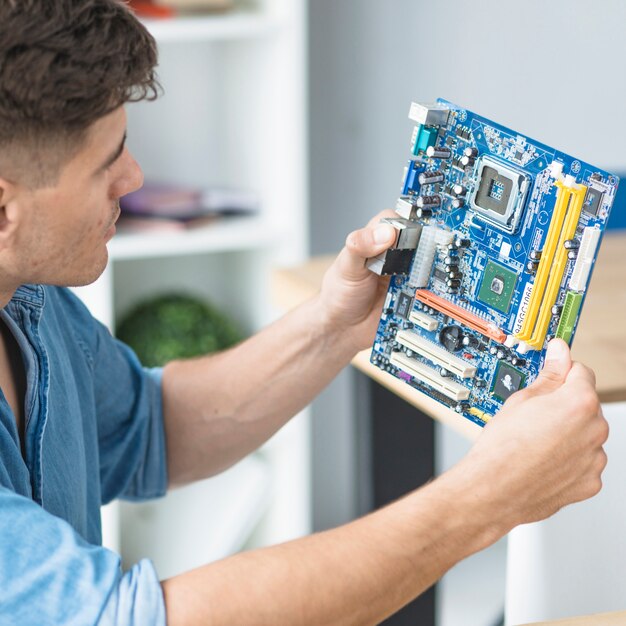 male it technician looking at pc motherboard