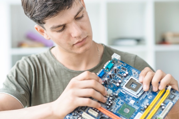 Foto gratuita tecnico it maschile che ripara la scheda madre