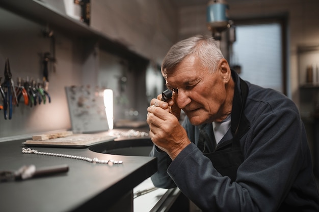 Free photo male jeweler working in the shop with magnifying glass