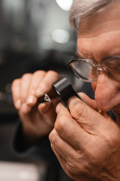 Free photo male jeweler working in the shop with magnifying glass