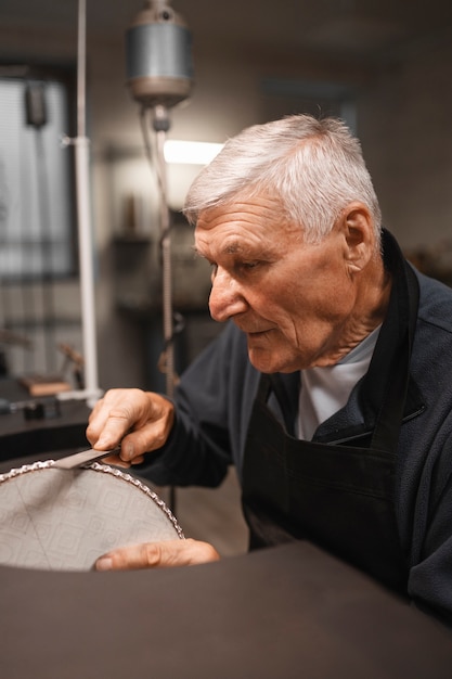 Free photo male jeweler working in the shop