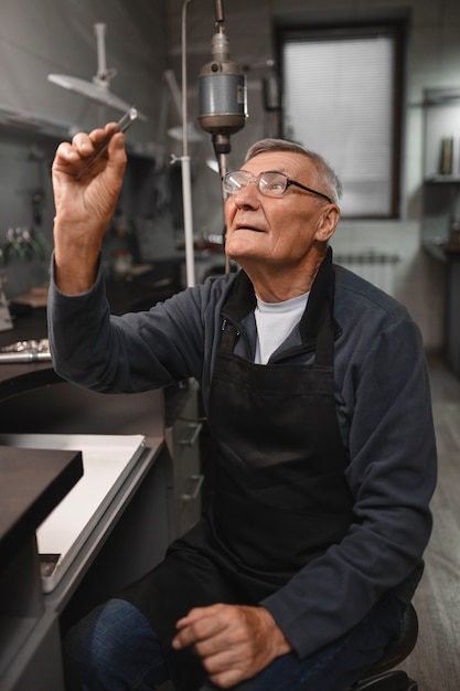 Free photo male jeweler working in the shop