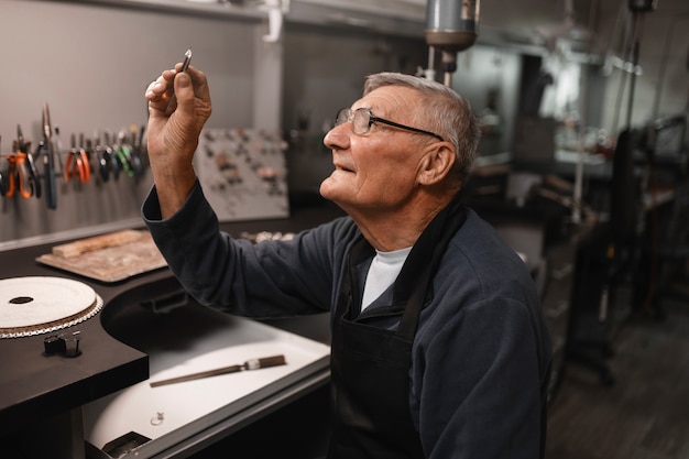 Free photo male jeweler working in the shop