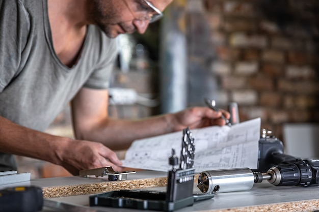 Male joiner in the process of working with wood in the workshop.