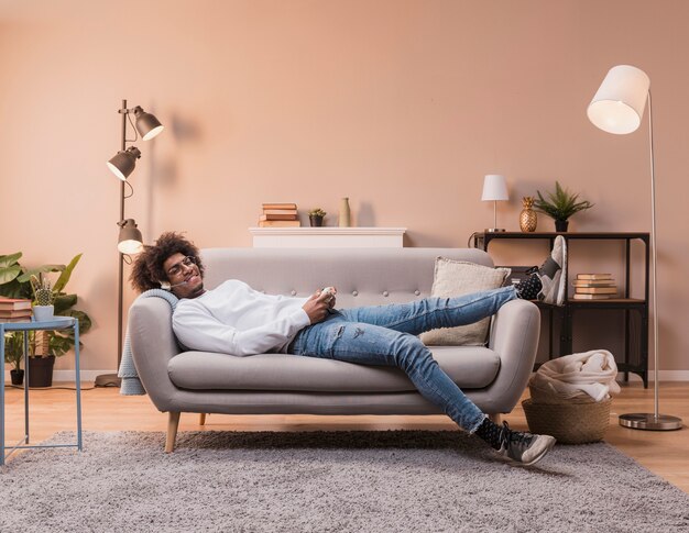 Male laid on couch playing games