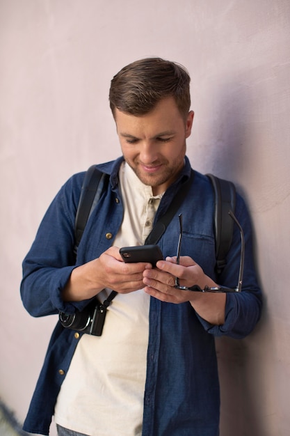 Foto gratuita viaggiatore locale maschio che controlla il suo telefono