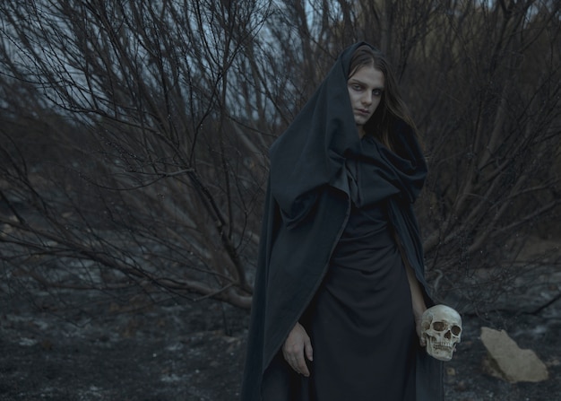 Male mage in black clothes with autumn branches