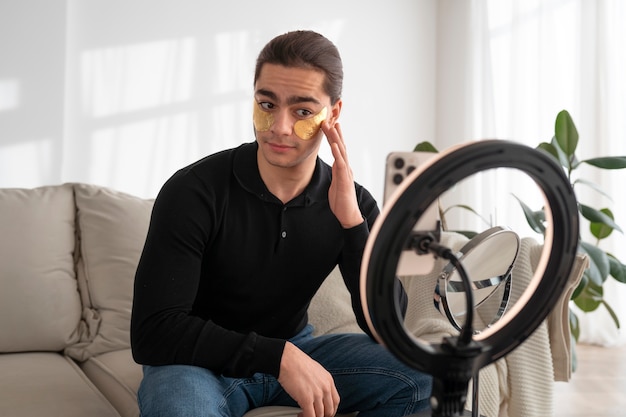 Male make-up artist putting on make-up on himself