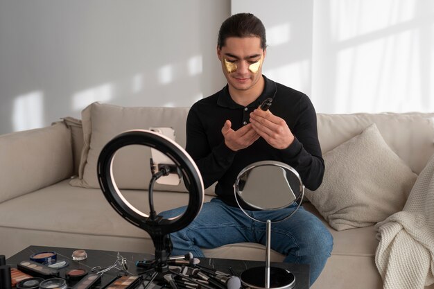 Male make-up artist putting on make-up on himself