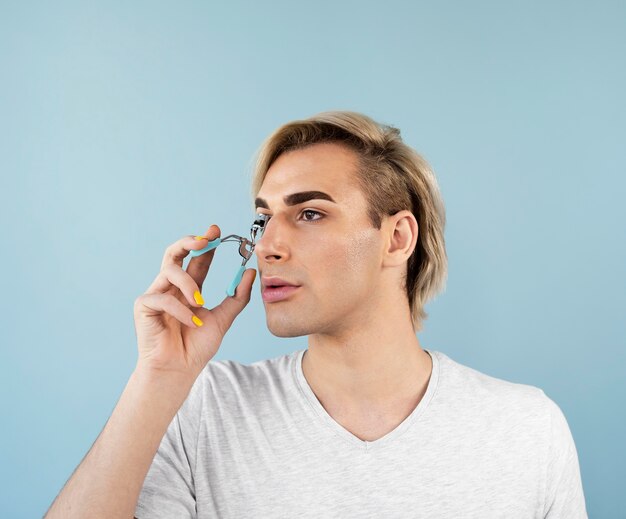 Male make-up look using an eyelash curler