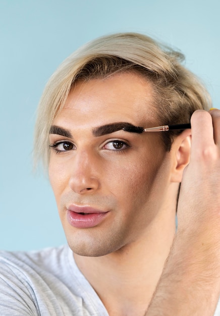 Male make-up look using his an eyebrow brush