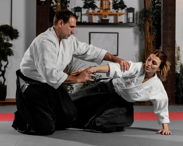 Male martial arts instructor and female trainee practicing