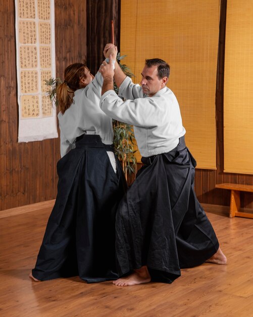 Male martial arts instructor in the practice hall training with female trainee