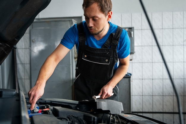 Meccanico maschio che lavora nell'officina riparazioni auto sull'automobile