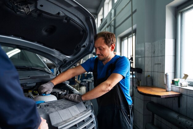 無料写真 自動車修理工場で車に取り組んでいる男性メカニック