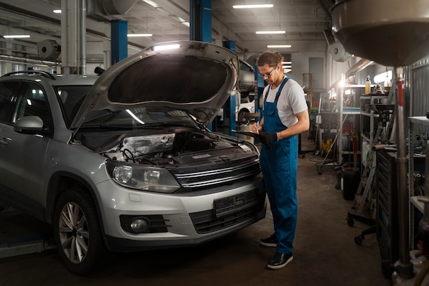 Male mechanic working in the shop on a car