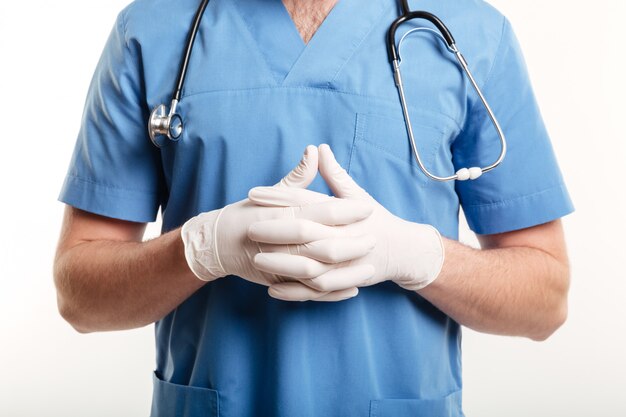 남성 의사 또는 간호사가 수술 장갑과 청진기를 착용