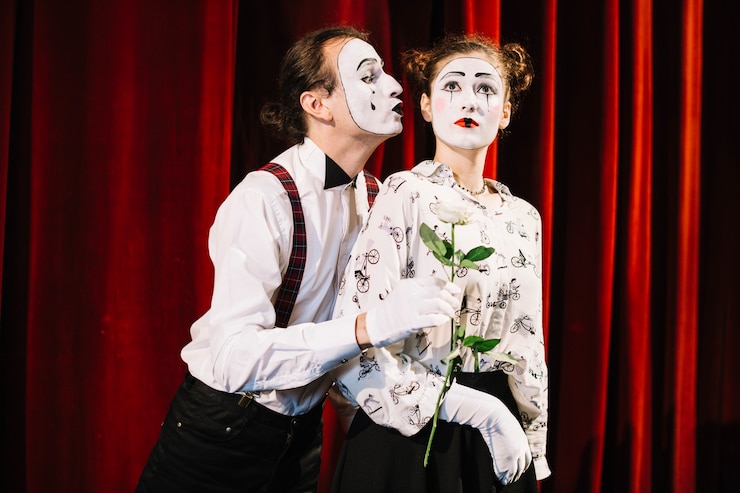 無料Photo 女性のmimeの前に白いバラを保有する男性のmime artist