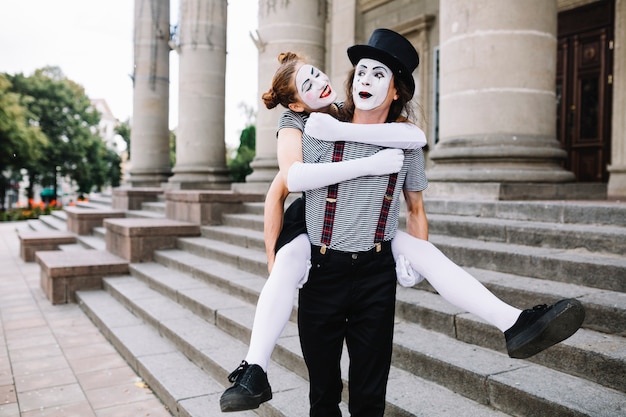 Male mime carrying female mime on his back