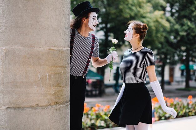 女性のmimeに花を与える男性のmime