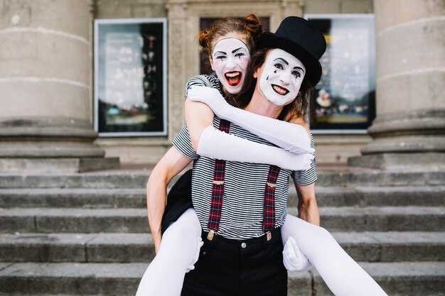 male mime giving piggyback ride to female mime