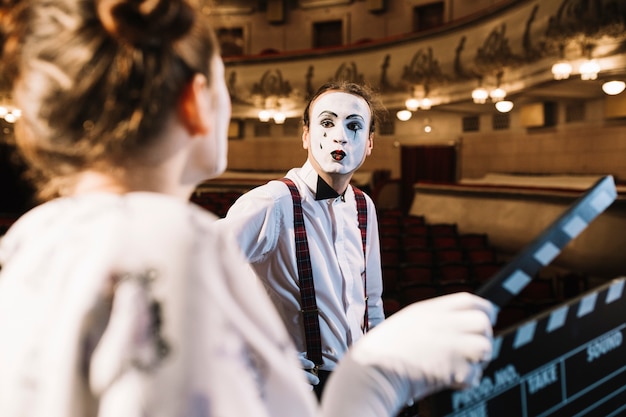 Foto gratuita mime maschio che fa il broncio al ciao femminile che tiene ciac