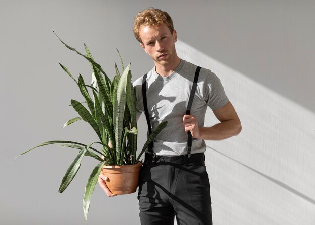 Male model holding a plant front view