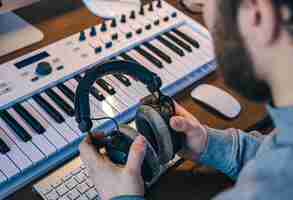 Free photo male musician creates music using computer and keyboard musician workplace