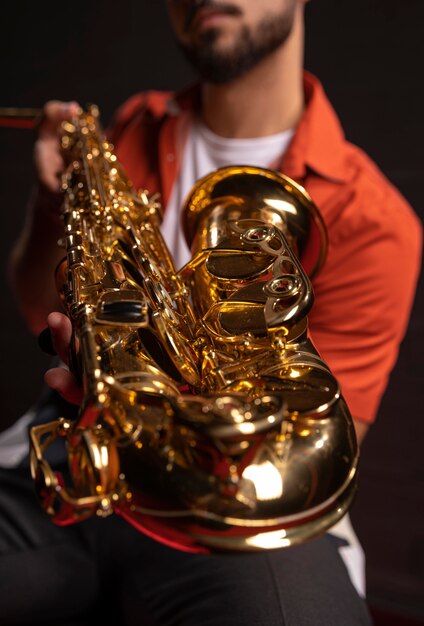 Мужской музыкант, держащий саксофон