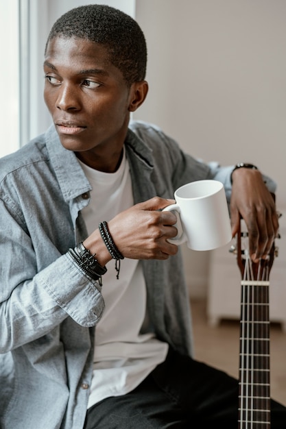 Male musician with guitar and mug