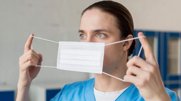 Мужской медсестра надевает медицинскую маску