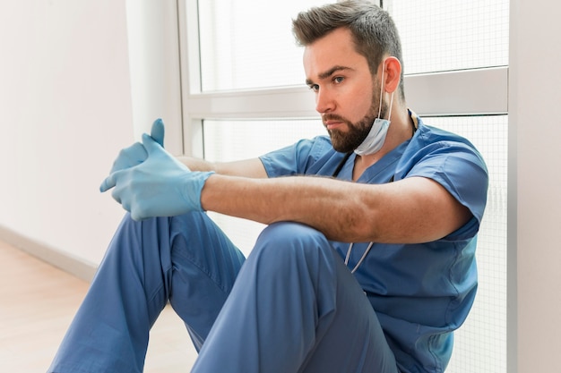 Free photo male nurse wearing surgical gloves