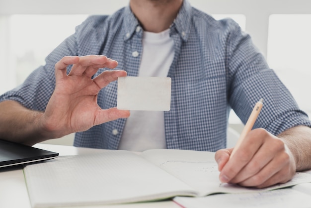 Male at office holding business card