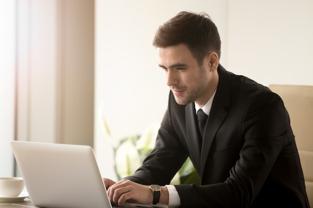 Male office worker working on laptop in office