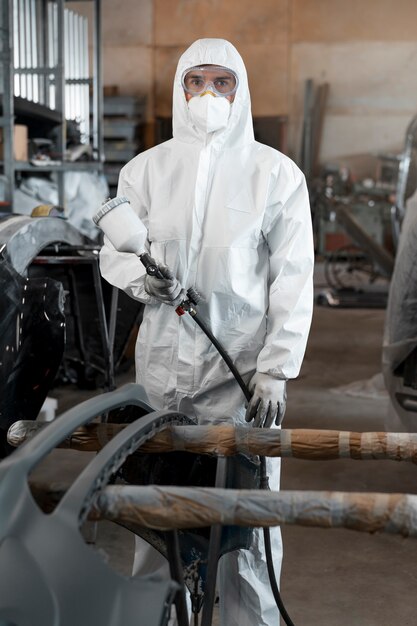 カーショップ内の化学防護服に身を包んだ男性画家