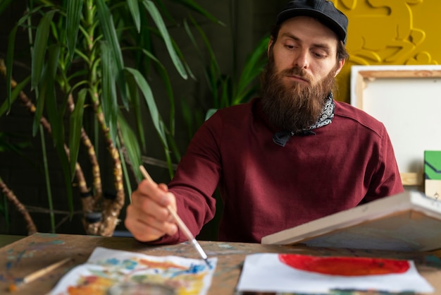 Male painter in the studio using watercolor on his art