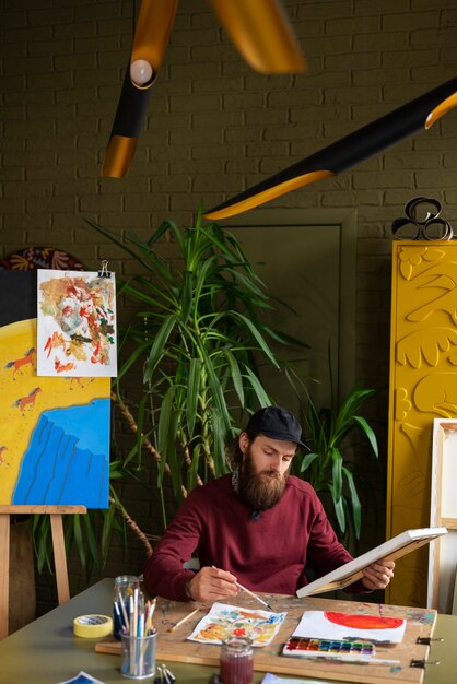 male painter in the studio using watercolor on his art