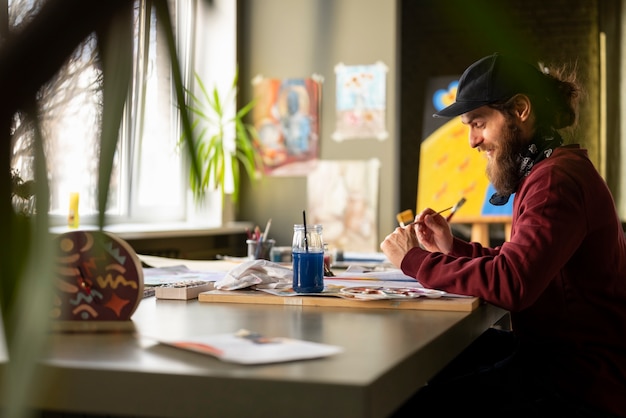 male painter in the studio using watercolor on his art