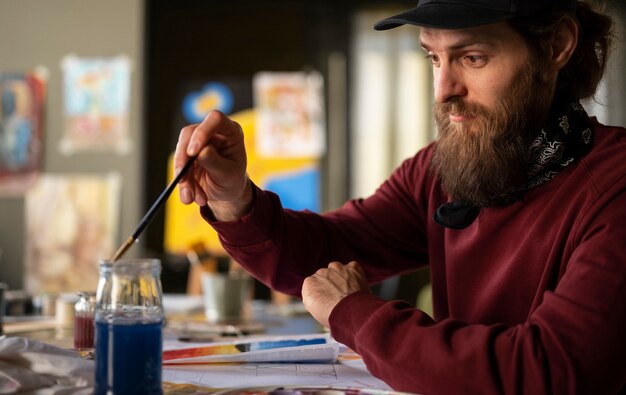 male painter in the studio using watercolor on his art