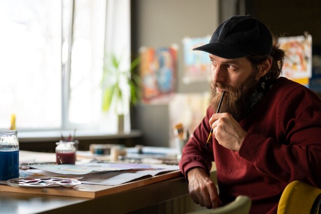male painter in the studio using watercolor on his art