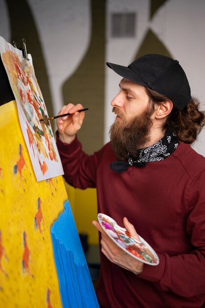 male painter in the studio using watercolor on his art