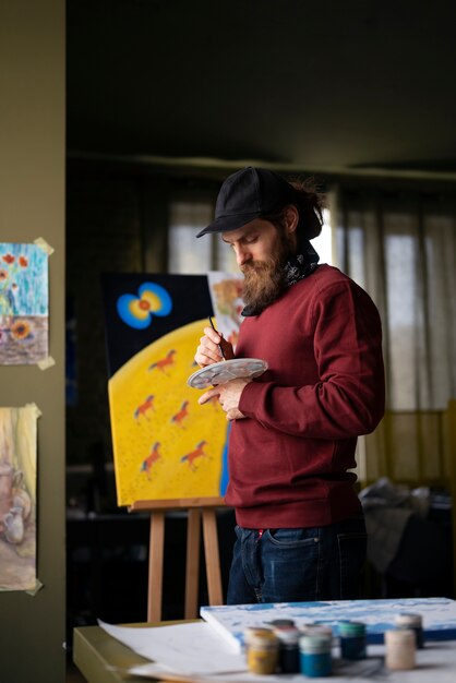 male painter in the studio using watercolor on his art
