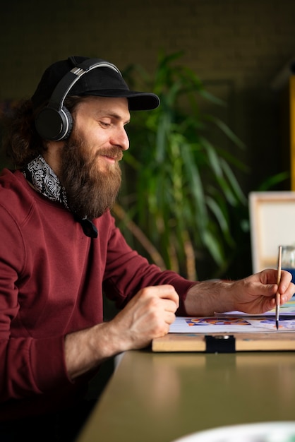 Male painter in the studio using watercolor on his art