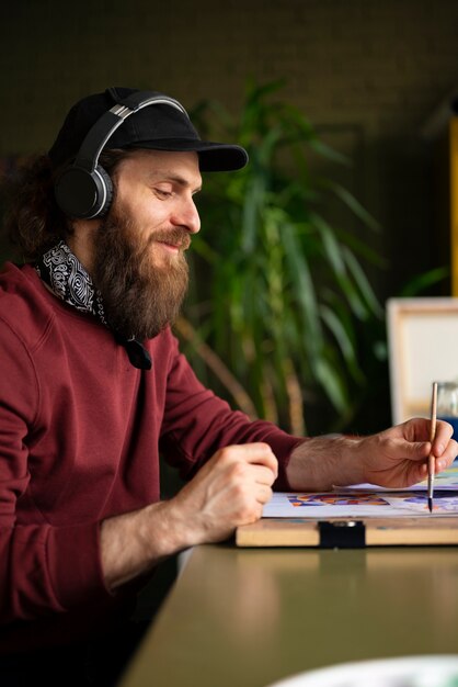 male painter in the studio using watercolor on his art