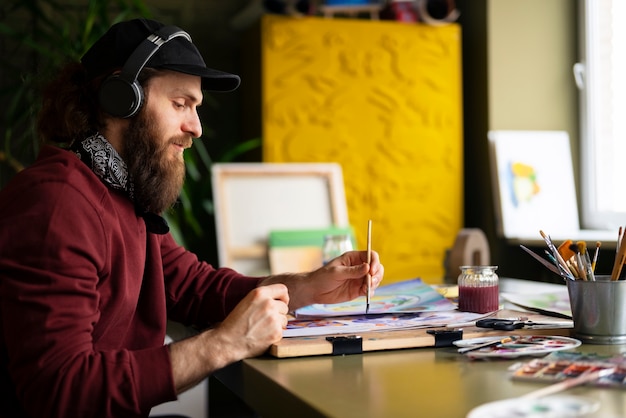 male painter in the studio using watercolor on his art
