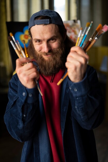 Male painter in the studio using watercolor on his art