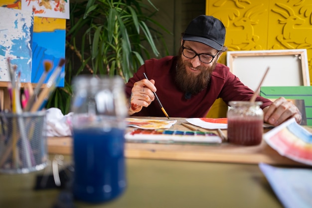 Male painter in the studio using watercolor for his art