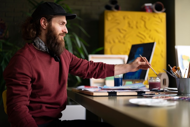 Male painter using watercolor on his art in the studio