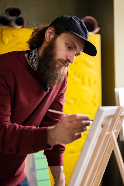 male painter using watercolor on his art in the studio