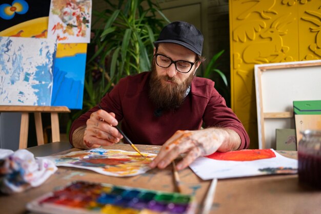 male painter using watercolor on his art in the studio